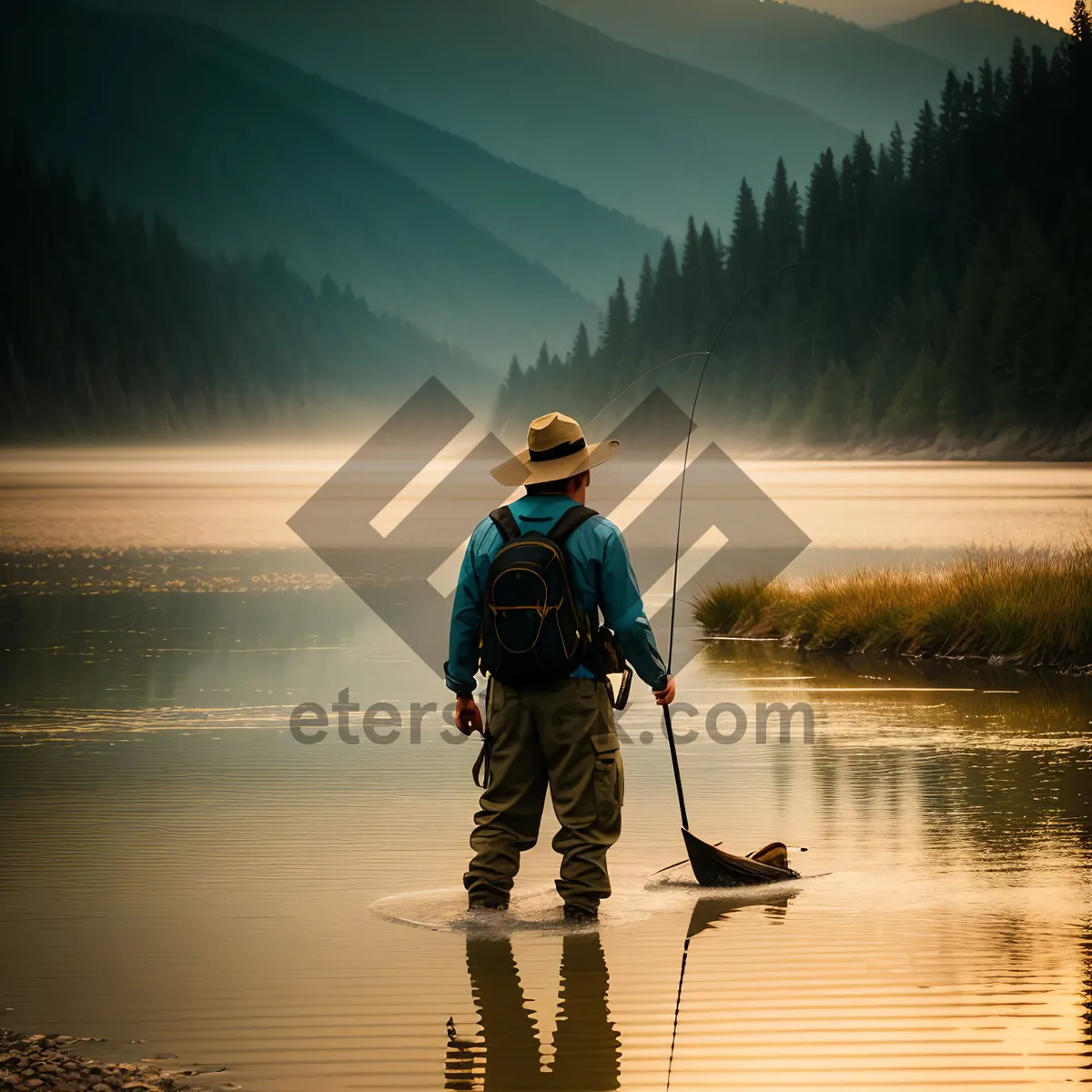 Picture of Fisherman enjoying serene lake and mountain backdrop