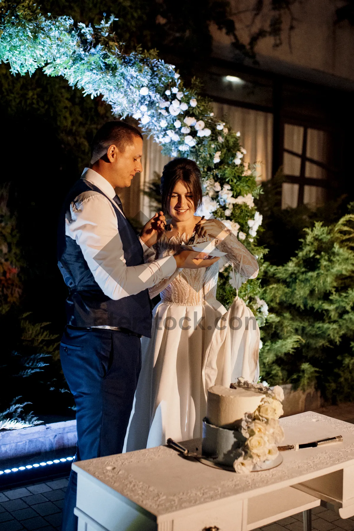 Picture of Smiling groom playing pipe for bride at wedding