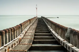 Wooden pier overlooking ocean with scenic clouds