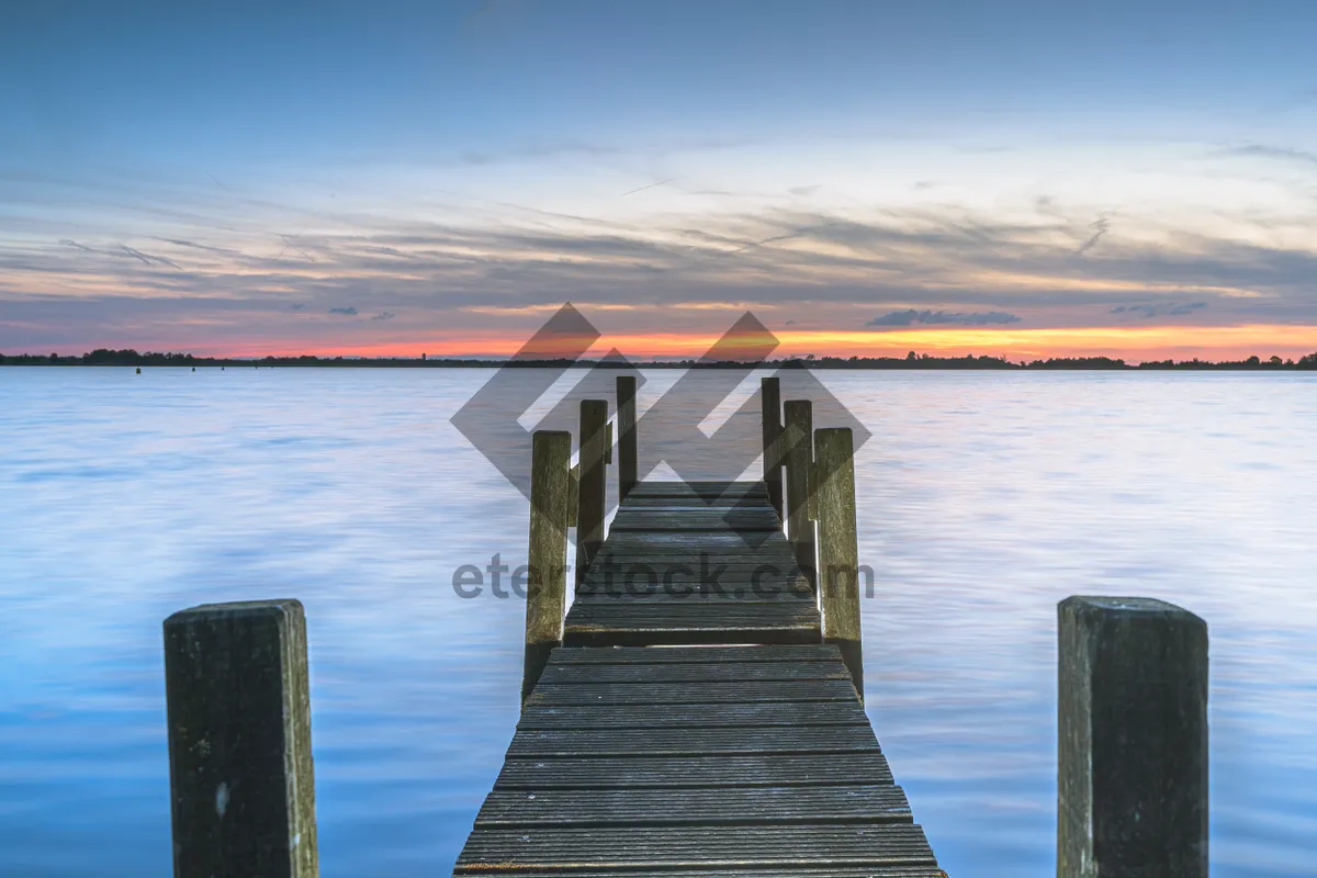 Picture of Pier overlooking tropical ocean landscape with wooden boat