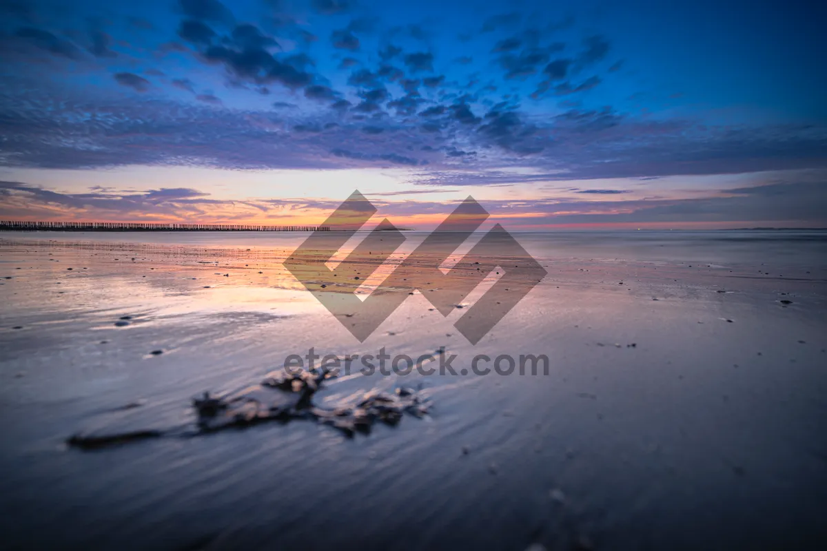 Picture of Tropical sunset beach landscape with waves and sun.