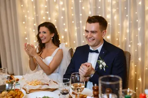 Happy adult couple celebrating wedding at restaurant table.