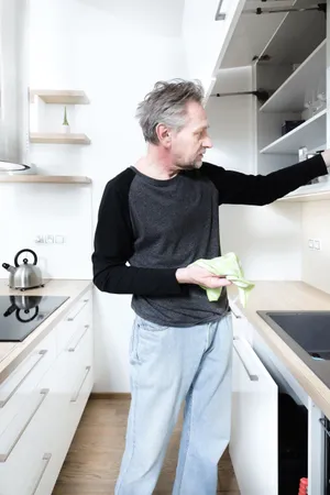 Happy man in kitchen with refrigerator and photocopier.