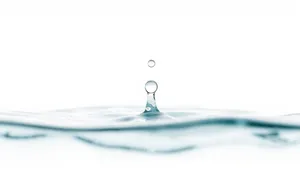 Clear water splash with bubbles on glass surface