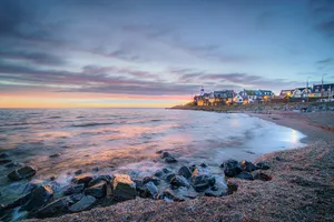 Sunset view of shipwreck on coastal rocks