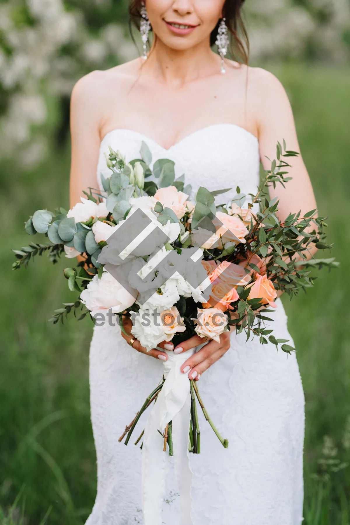 Picture of Happy bride with rose bouquet in garden wedding decoration.