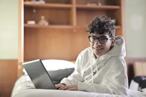 Happy businessman working on laptop in modern office