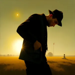 Silhouette of man enjoying sunset at beach.