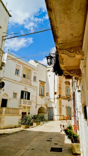 Historic stone monastery with balcony overlooking ancient cityscape.