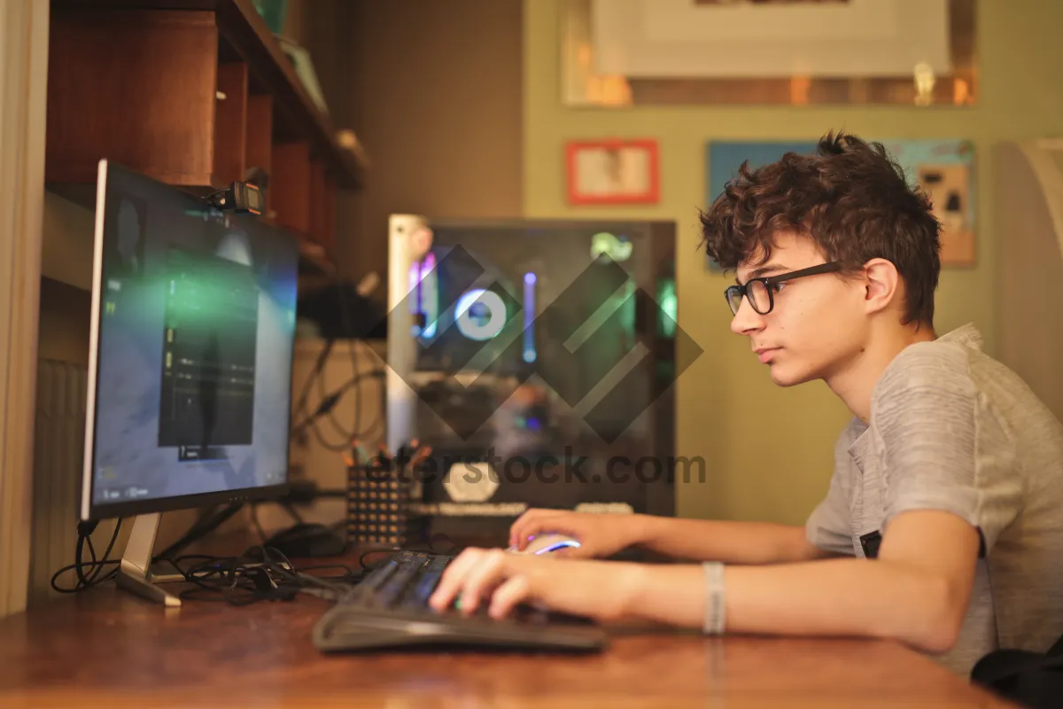 Picture of Businesswoman working on laptop at office desk with monitor.