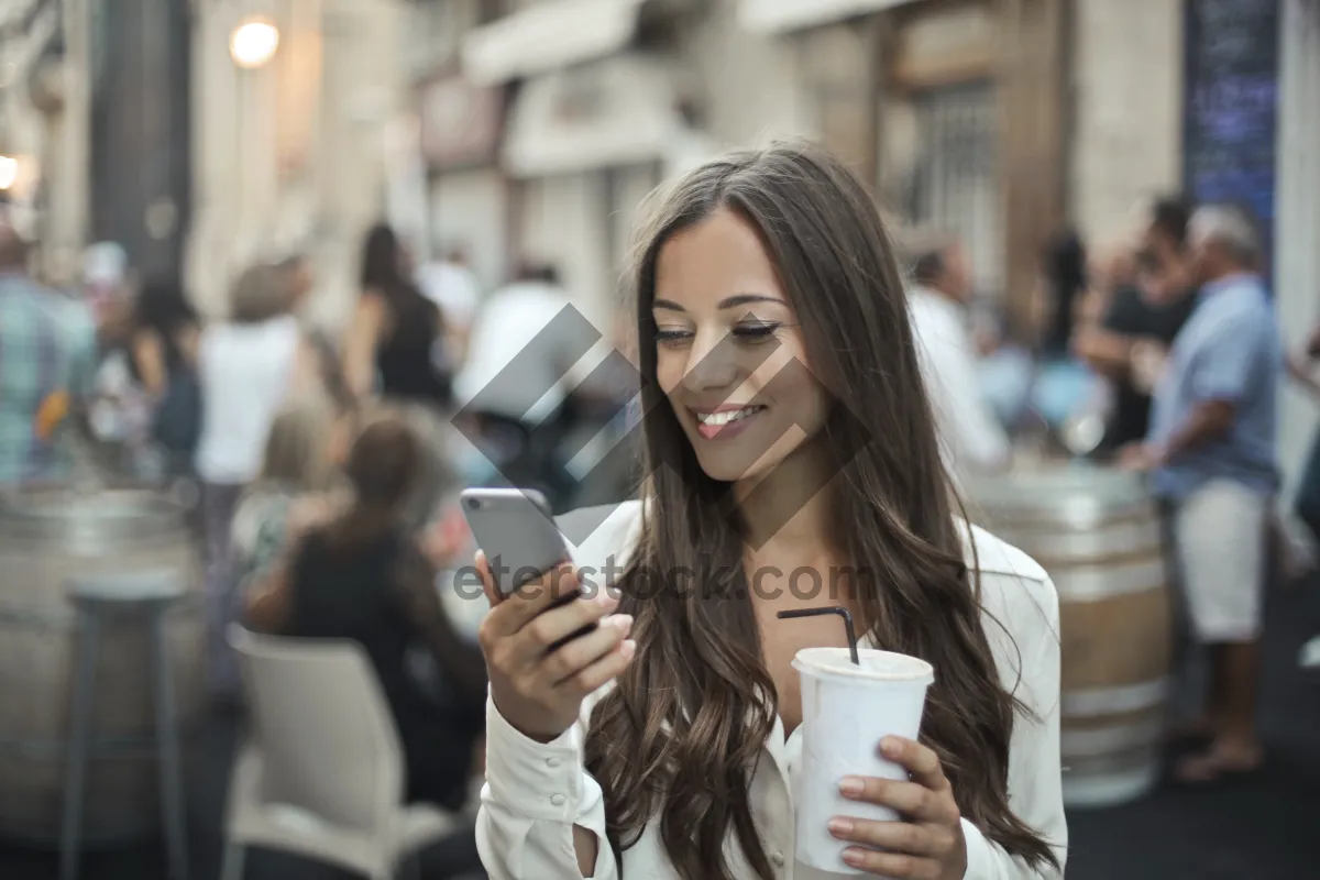 Picture of Happy brunette businesswoman sitting at cafe holding coffee