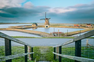 Suspension bridge over river in urban cityscape.