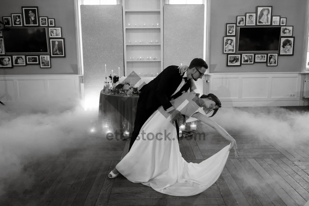 Picture of Happy couple celebrating wedding with bouquet of flowers