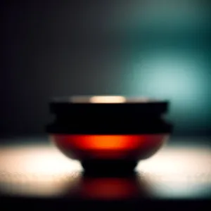 Wineglass filled with rich red beverage in dimly lit restaurant.