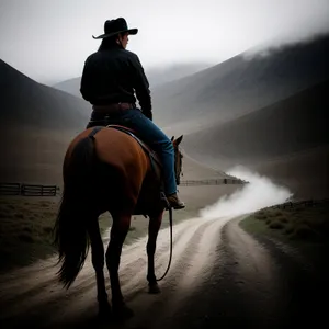 Silhouette of Cowboy Riding Horse at Sunset