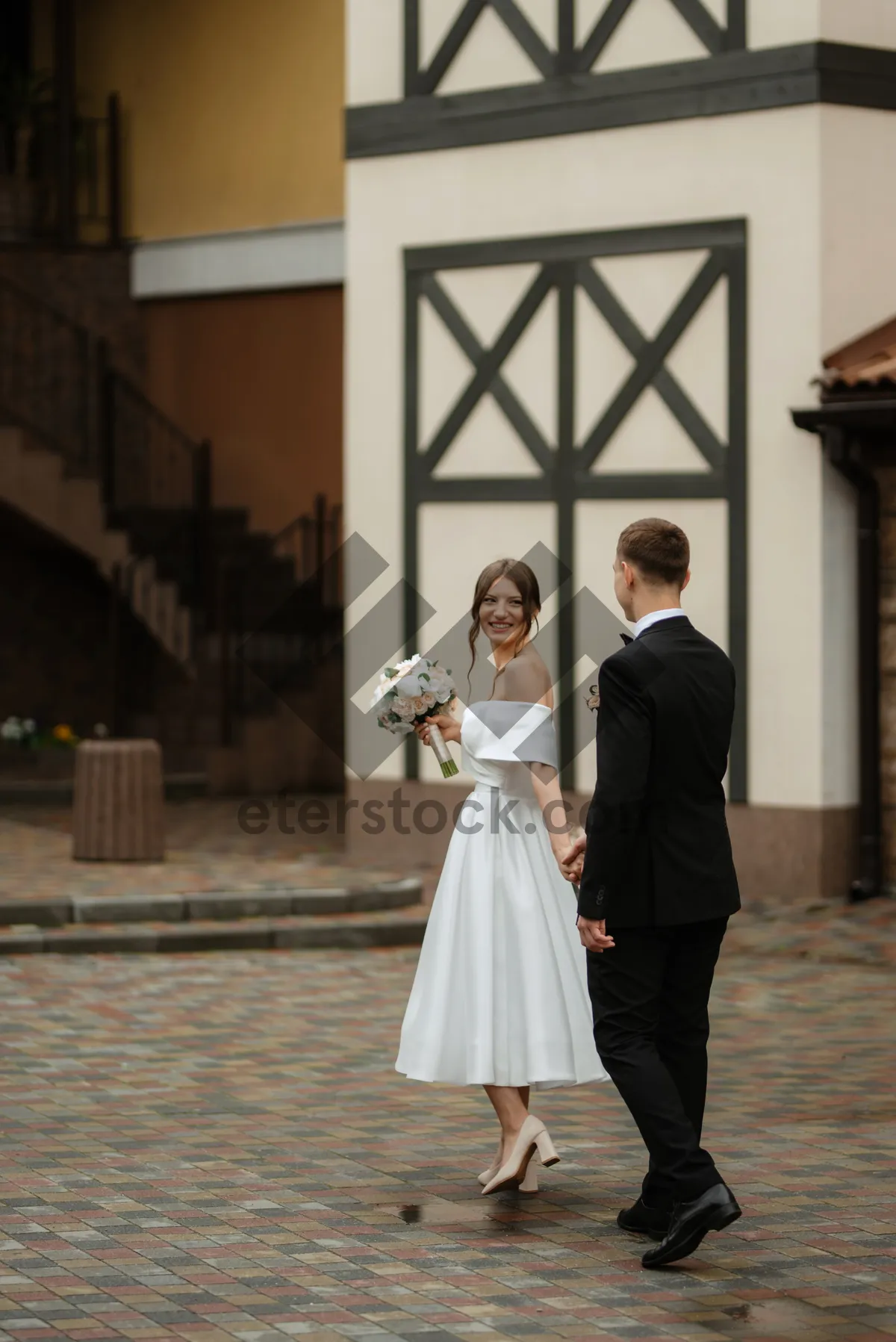 Picture of Happy wedding couple with bouquet of flowers.