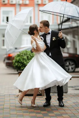 Happy Wedding Couple Outdoors Smiling Together with Flower Bouquet