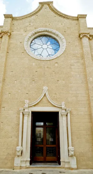 Ancient cathedral facade with arched windows and doors.