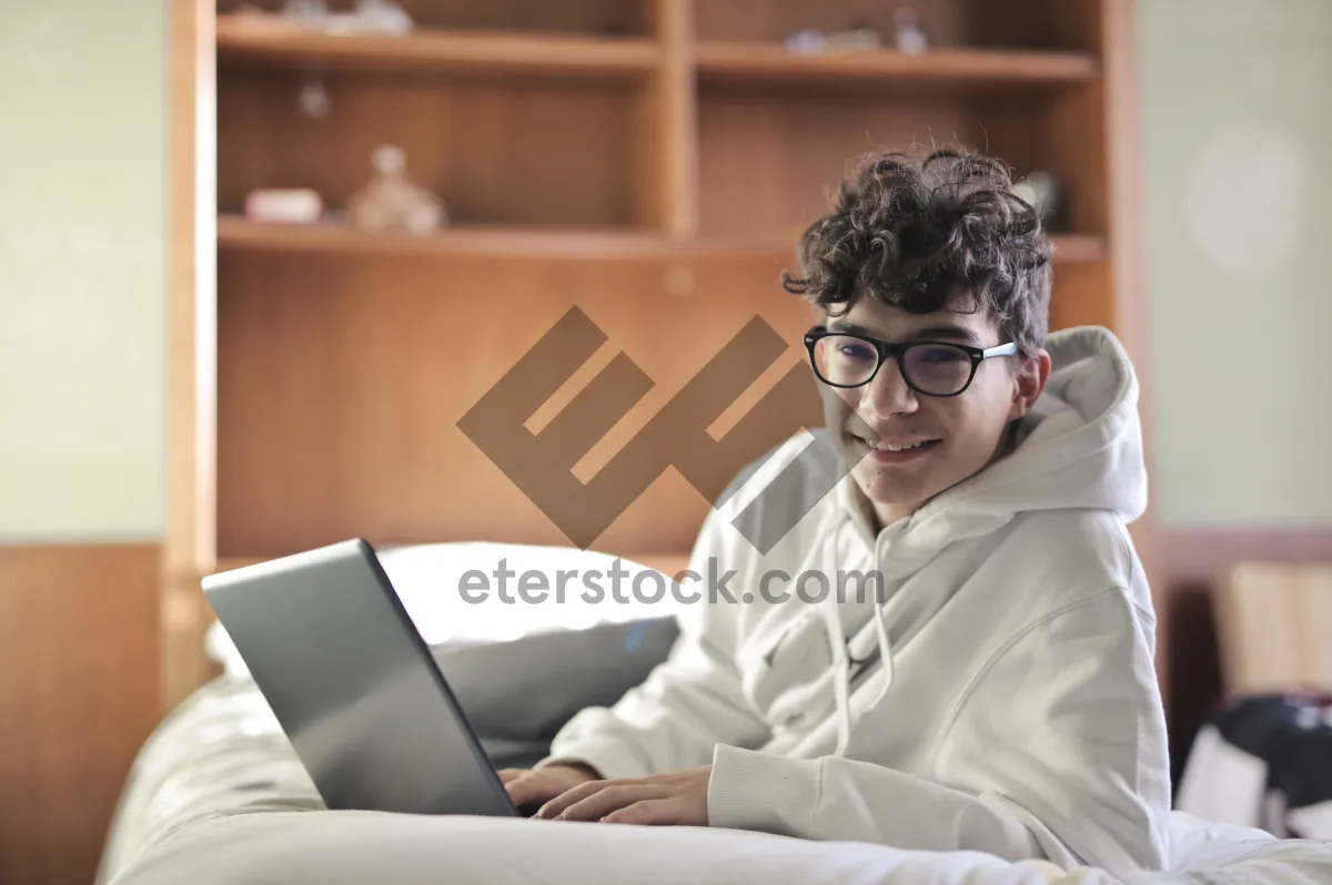 Picture of Happy businessman working on laptop in modern office