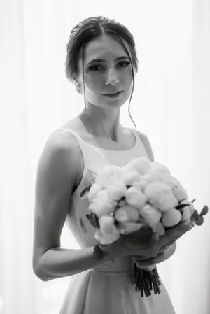 Attractive bride holding bouquet of blackberries and flowers