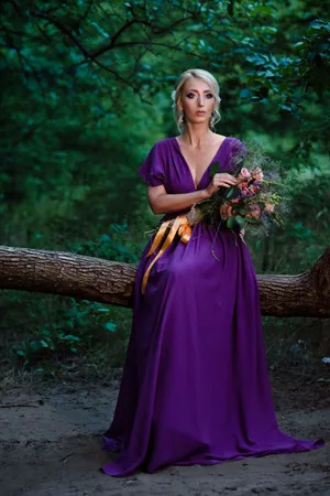 Fashionable bride in elegant wedding dress smiling happily.