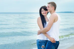 Happy couple in swimsuits at tropical beach