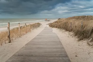 Serene beach landscape with barrier and clouds