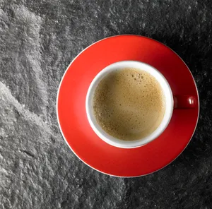 Morning coffee in black china cup on table