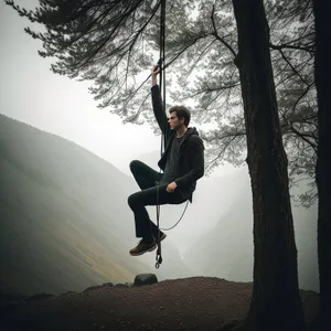 Mountain Swing: Adventurous Man Enjoying Outdoor Winter Play