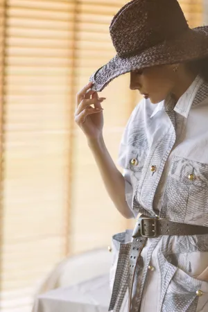 Attractive lady in cowboy hat smiling happily.