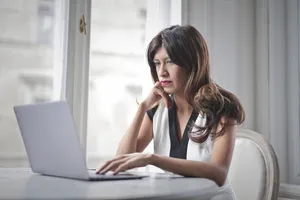 Attractive brunette businesswoman working on laptop at office desk