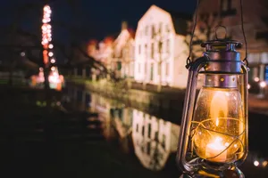 City lights reflecting on bridge over river at night.