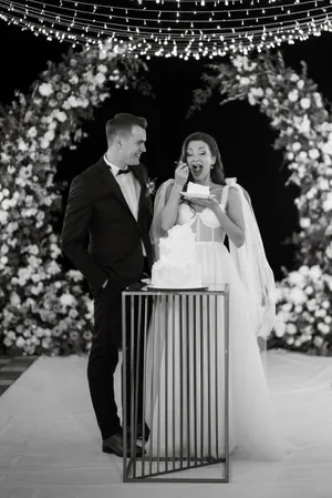 Happy couple in wedding attire with bouquet outdoors
