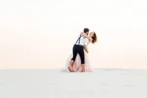 Happy newlywed couple smiling on beach vacation.