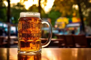 Golden beer glass with frothy bubbles at restaurant party.