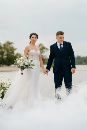 Happy newlywed couple outdoors on wedding day smiling together