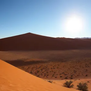 Sizzling Sahara: Majestic Orange Dunes Under Sunny Sky