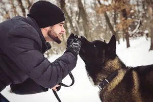 Happy winter portrait of person and dog outdoors.