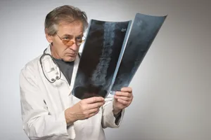 Professional male doctor in lab coat performing surgery.