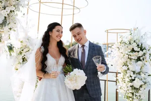 Happy newlywed couple holding bouquet at wedding ceremony