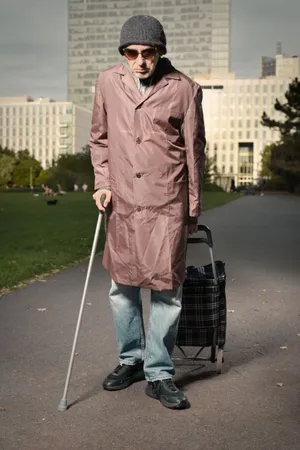 Male golfer with crutch on golf course walking.