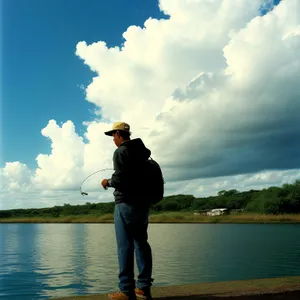 Man fishing by the beach at sunset