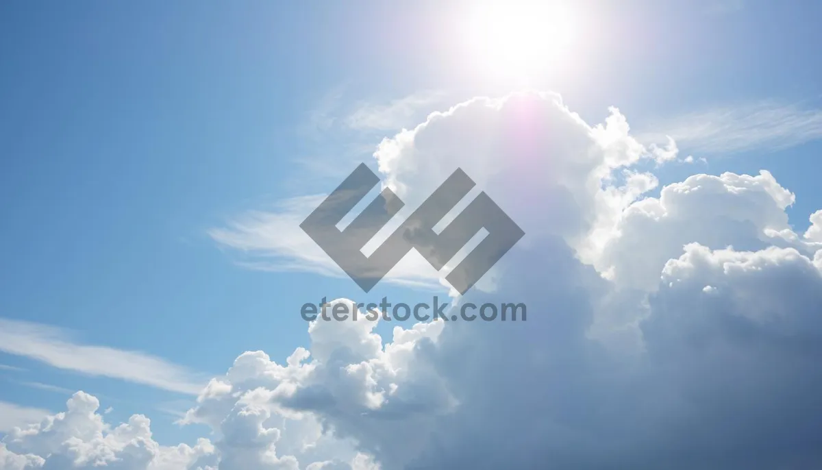 Picture of Vibrant summer sky with fluffy clouds and bright sun.