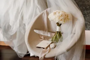 Wedding couple with rose bouquet at ceremony