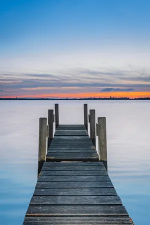 Tropical beach pier with wooden bridge and boat.