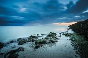 Tropical sunset beach landscape with waves and sun.