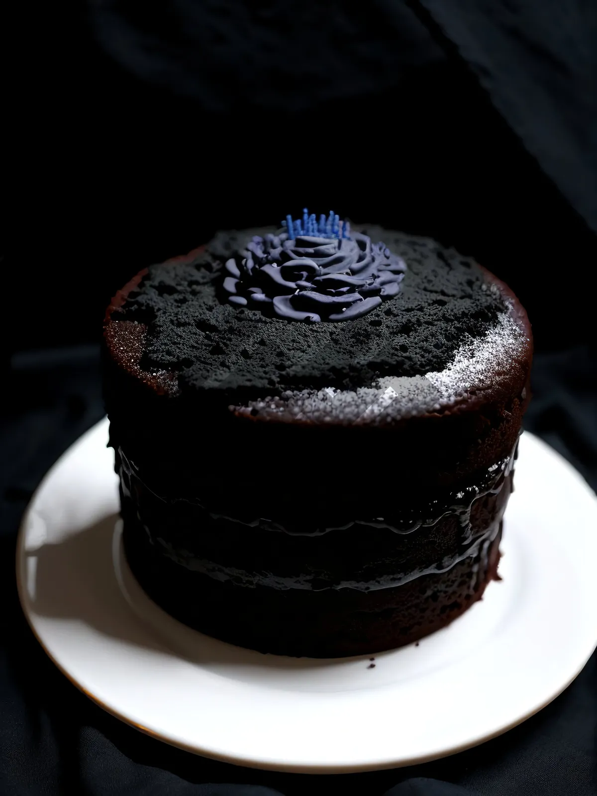 Picture of Decadent chocolate cake with creamy frosting and sugar garnish.