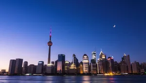 Modern business district skyline at night with river reflections.