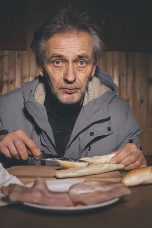 Happy elderly man sitting at home with glasses