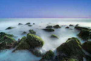 Tropical paradise beachscape with rocky coastline and crystal waters.